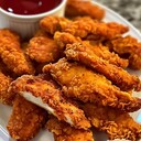 CHICKEN TENDERSIngredients:1 lb chicken tenders1 cup buttermilk1 cup flour1 tsp paprika1 tsp garlic powder1 tsp onion powderSalt and pepper to taste2 cups vegetable oil for fryingDirections:1. Marinate Chicken: Place chicken tenders in a bowl and pour buttermilk over them. Let marinate for at least 30 minutes.2. Prepare Coating: In a separate bowl, combine flour, paprika, garlic powder, onion powder, salt, and pepper.3. Coat Chicken: Dredge each chicken tender in the flour mixture, ensuring an even coating.4. Fry Chicken: Heat vegetable oil in a large skillet over medium-high heat. Fry chicken tenders for 3-4 minutes per side, until golden brown and cooked through.