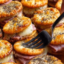 Ritz Crackers Party SandwichesINGREDIENTS48 Ritz crackers8 slices of deli ham8 slices of Swiss cheese4 tablespoons of melted butter2 teaspoons of Dijon mustard1 teaspoon of Worcestershire sauce1/2 teaspoon of garlic powder1 teaspoon of poppy seeds1/2 teaspoon of dried minced onionINSTRUCTIONSPreheat your oven to 350°F (175°C).Arrange half of the crackers in a 9x13-inch baking dish, placing them flat side down.Rip the ham slices into small strips, fold them, and place on each cracker.Slice the cheese into 1-inch pieces and place one on each ham-topped cracker. Cover with another cracker to form mini sandwiches.In a small bowl, combine the melted butter, Dijon mustard, Worcestershire sauce, and garlic powder. Drizzle this mixture evenly over the cracker sandwiches.Evenly sprinkle the poppy seeds and dried minced onion over the sandwiches.Bake in the preheated oven until the cheese is melted and the tops are golden brown, about 10-12 minutes.Serve warm